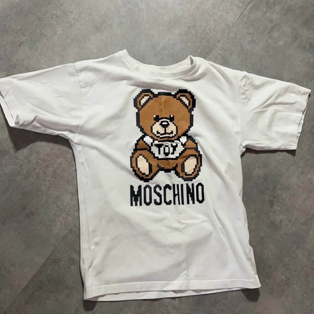 En äkta Moschino t-shirt storlek 150cm. den har tappat lite färg men ändå skit fin.. T-shirts.
