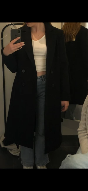 Lång kappa från Lindex strl s - Lång kappa från Lindex Svart i strl s Personen på bilden är 165cm Nypris 1300kr Mitt pris 500kr  