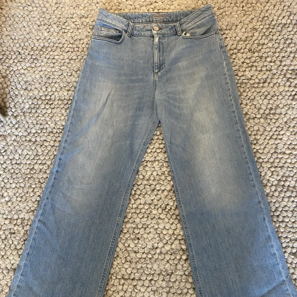 Supersnygga Filippa K jeans i ljusblå färg med lägre midja. Lätt vida eller flared. Något slitna vid knappen samt litet hål vid en av öglorna.. Jeans & Byxor.