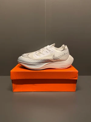 Nike ZoomX VaporFly Next - Nike ZoomX VaporFly Next% 2 sneakers är det ultimata valet för löpare som strävar efter prestanda och komfort. Dessa skor är en imponerande kombination av avancerad teknologi och stil.  