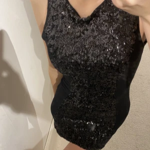 Klänning - En svart plajetklänning. Perfekt till nyår eller en fest! Sitter galet snyggt, perfekt längd! Paljetter på ”framsidan” och svart tyg runt om! Dragkejda bak. Skicket är bra! Kan skicka mer bilder! Storlek 36!  Frakt tillkommer! 