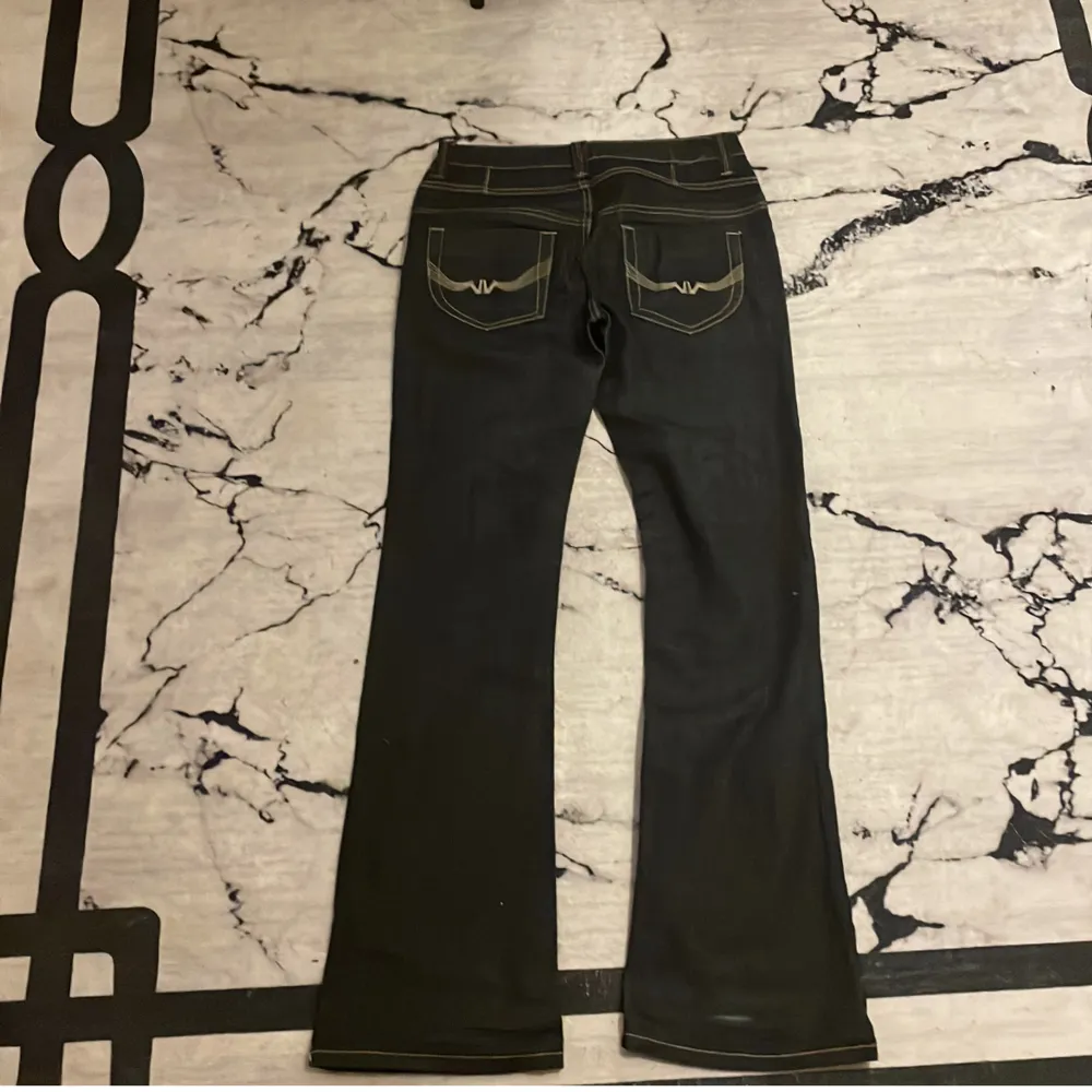 Säljer ett par blåa lågmidjade bootcut jeans med snyggt mönster på bakre fickorna. Materialet på jeansen är inte stretchigt men i mycket bra skick på grund av att det aldrig har används men dock är knappen lite lös men inget som hindrar än från att ha på.. Jeans & Byxor.