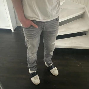 Grå jeans - Säljer mina grå ripped jeans i fint skick. Storlek 32/32. Fint skick, inga större tecken på användning. Hör gärna av er vid ytterligare frågor!
