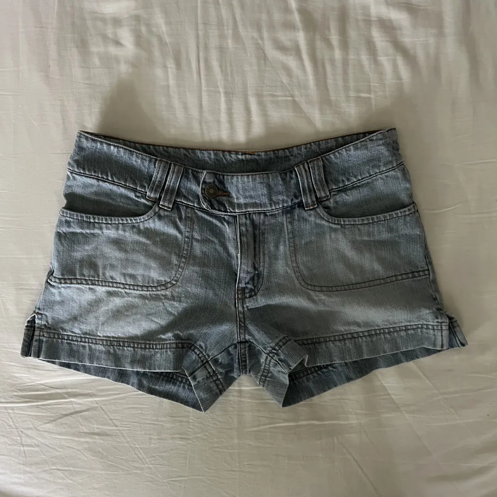 Skit snygga vintage ljusblå lågmidjade jeansshorts med unika bakfickor. Begagnat skick, men inga fläckar eller hål! Midjemått mätt rakt över: 40cm, längd: 28. Storlek 38 men passar även 36🫶💕 . Shorts.