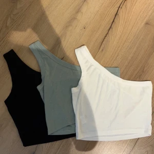 One shoulder toppar - Tre stycken one shoulder toppar från SHEIN, i storlek M. Aldrig använda för att de är förstora för mig. 15kr st eller 40kr för alla tre😻