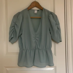 Ljusblå blus  - V-ringad blus. Tunt tyg och perfekt en varm sommardag. Fint skick och säljs pga att den inte längre passar mig 