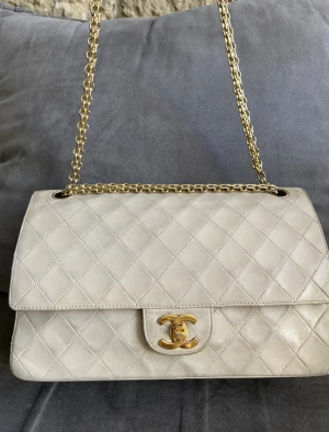 Chanel double flap  - Säljer nu min chanel double flap medium. Välanvänd men har mycket kvar att ge. Beige med guld. Har reparerats innuti en liten del av sidan. Finns äkthetsintyg samt dustbag. 