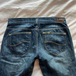 Jättesnygga aslågmidjade lee jeans! Midjemått tvärs över är 40, men de sitter ju ganska långt ner så är inte riktigt 