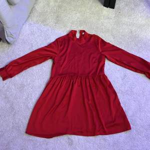 En gullig röd klänning med liten krage och lätt puffiga ärmar, storlek 40.
