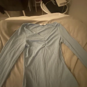 Ljusblå tröja  - En jättefin ljusblå urringad tröja . Storlek M men jag som har XS passade den mig . Jätte stressig tröja . Tröjan kommer tyvärr inte till andväning. 