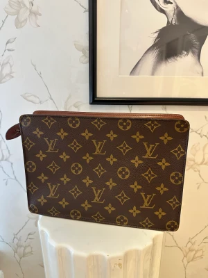 Louis Vuitton Pouch/Kuvertväska - Säljer nu denna fina pouch/ clutchen som jag fått i present för flera ar sedan men som tyvärr inte kommer till någon användning. Stort utrymme och bra storlek. Den är använd, men i väldigt bra skick. Pris går att diskutera vid snabb affär.