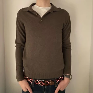 Rugby tröja - Säljer denna bruna Rugby tröja från Grand Frank som är i toppen skick! Modellen på bilden är 184cm och väger 74kg