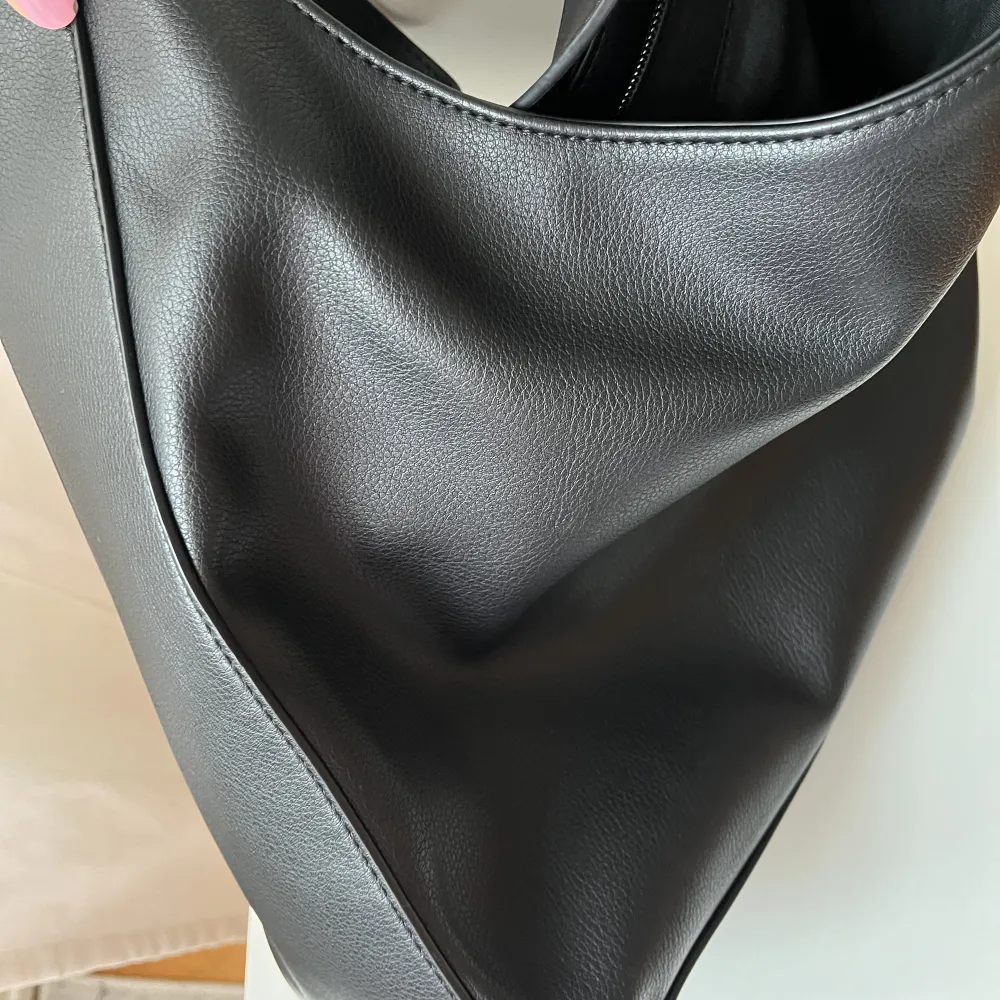 En svart handväska från Åhléns, varsamt använd.  100% återvunnet polyester . Väskor.