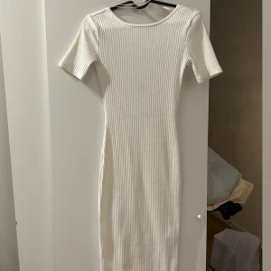 Vit långklänning med öppenrygg  - Helt oanvänd vit klänning med öppen rygg som är väldigt stretchig och ger fina former och som även går ner till knäna i storlek xxs 