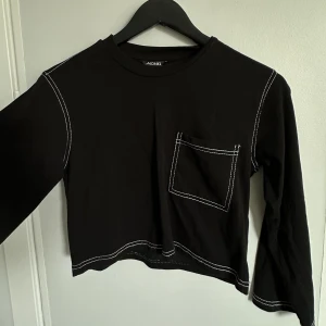 Monki topp strl. XXS - En långärmad croppad svart topp från Monki i storlek XXS. Använd ett fåtal gånger men är i mycket fint skick. 