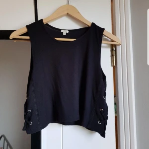 Svart crop top - Svart croptop från OVS Italia, köpt på Capri. Storlek S, axelbredd: 29 cm, längd: 40 cm. 96% viscose, 4% elastane. Är i mycket bra skick och köptes för ca 300 kr.