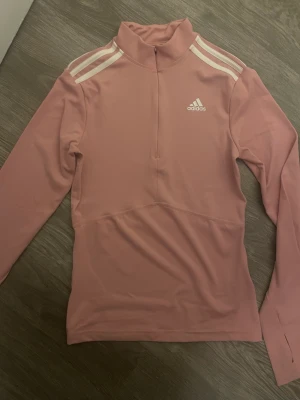 Träningströja  - Superfin träningströja från Adidas i storlek S. Den är i färgen rosa och är normal i storleken. Stretchigt material och är superfin att bära till vardagen och när man ska träna. Tröjan har en liten dragskedja som man kan justera hur man vill. 