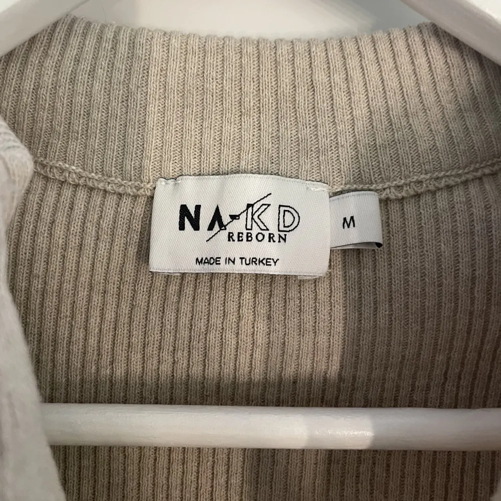 Beige långärmad tröja med ribbade detaljer+En halv dragkedja🤍 Köpt från NAKD och har använts färre än 5 gånger. Bra kvalitet och skönt material! Betalning sker via Swish, köparen står för frakten, står ej för påstens slarv!. Tröjor & Koftor.