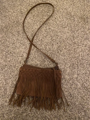 Mocka väska  - Jag har en väska i mocka som jag aldrig har använt. Inte riktigt min smak men den är som ny och har inga skador💘💕Jag säljer den för 300kr + frakt och materialet är mocka och märket är Indiska💕