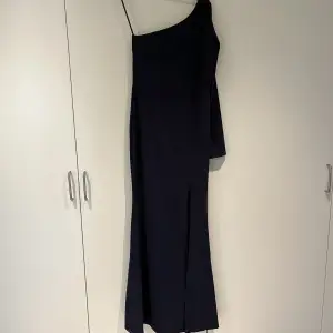 Mörkblå maxiklänning med en lång arm och slits från WalG. Andlig använd, endast testad.