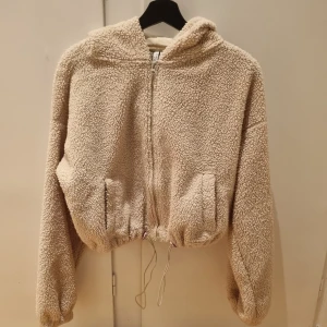 Teddy pile crop top - Beige croppad teddy tröja ( utan foder) från nelly, bra skick men defekt finns i luvan, inget som syns 😊 ( bild 3) 