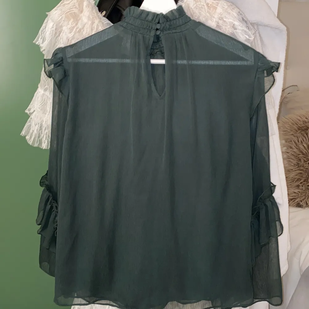 En gullig grön blus från H&M med urringning fram, vida armar och volanger! Säljer då den inte kommer till användning🤍. Blusar.