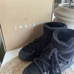 Inukikii - Svarta inuikiis från förra vintern använda 4-5 gånger. Fint skick och köptes för 2300 nypris. Jätte fina, söta och varma skor till vintern. Box kommer med❤️TRYCK INTE PÅ KÖP NU