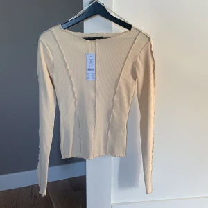 Top från ginatricot  - Beige/Creme färgad topp från ginatricot i storlek s. Aldrig använd. Ny med tagsen kvar,
