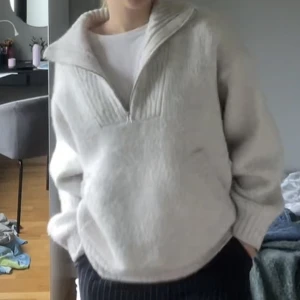 Grå stickad tröja - Grå stickad tröja med Half zip och stor ficka på magen! Jättetjock tröja så är perfekt nu när det blir kallare!