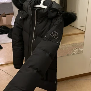 Moose Knuckles jacka - Köpt på jhonells för ett halvår sedan, använd Max 3 gånger. Inga skador och det finns en liknande scanner. Äkta självklart och kan skicka bild på kvitto privat. Detaljer är silvriga och äkta päls!