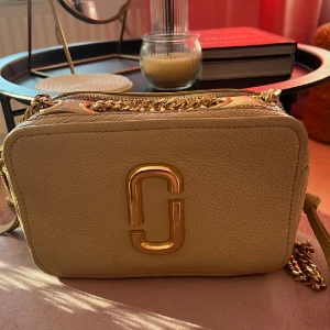 Marc Jacobs väska  - Säljer min Marc Jacobs väska från Johnells. Är i väldigt bra skick och jag har äktahetsbevis samt medföljande påse. Nypriset är 5499kr