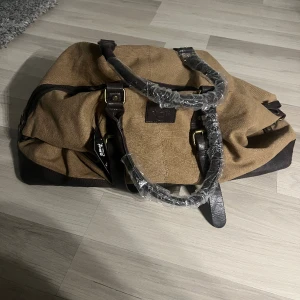 Weekendbag Sandhamn - Den perfekta julklappen!!  Helt ny weekend väska från Sandhamn. Aldrig använd. Färgen är Oliv. Mitt pris är 500kr. Nypris är 900kr. Finns i Göteborg men kan också fraktas. Hör av er angående fler frågor!
