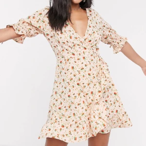 Omlottklänning wednesday’s girl - En blommig omlottklänning i minimodell med knytning på armarna❣️Den är i utmärkt skick, oanvänd och har lappen kvar! 