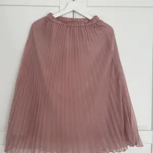 En rosa plisserad kjol från hm med små små märken som knappt syns i verkligheten (se bild)