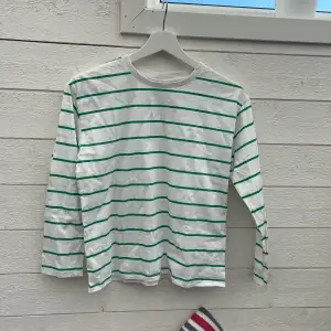 En grön och vit långärmad tröja från Kappahl. Använd ett fåtal gånger. Har små fläckar som knappt är synliga. De gröna ränderna är lite ljusare i verkligheten.