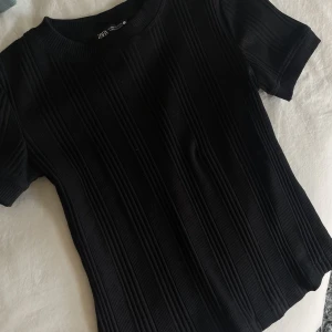 Topp - Svart t-shirt, i ett ribbat material, från Zara, samma som den vita! Aldrig använd, pga fel storlek! 🖤
