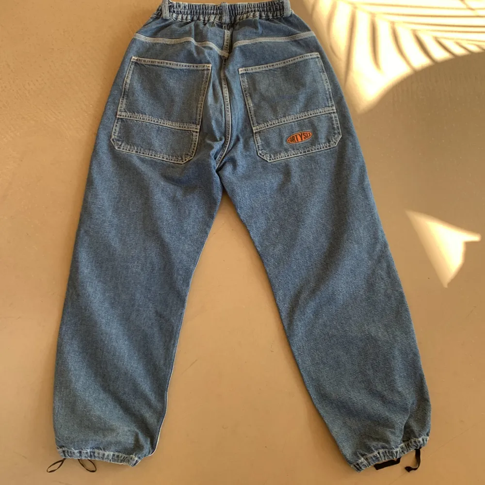 Baggy mörkblåa jeans från District 46, drawstrings vid fötterna och strechig midja, knappast använda och i bra kondition.. Jeans & Byxor.