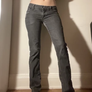 Lågmidjade gråa bootcut byxor - Lågmidjade utsvängda typ kostymbyxor i mörkgrått. Sitter fett snyggt och är bekväma. Passar mig som är s-m och 165 cm. Innerbenslängd: 78 cm. Tvärs över midjan: 38 cm. Fake fickor bak men finns fickor på framsidan. Kan mötas nära Mariatorget eller posta. 