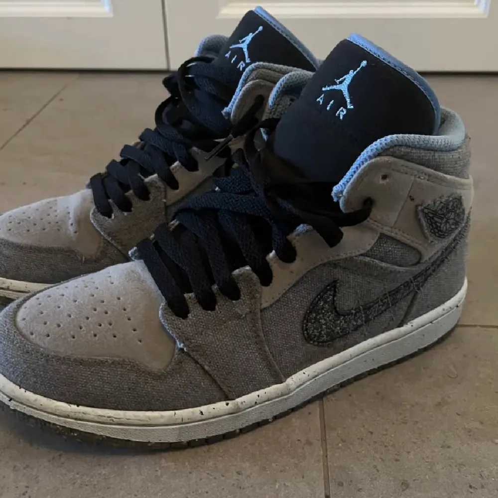 Säljer mina Air Jordan 1 Mid Crater Grey University Blue. Storlek EU 40/ UK 6. Snygga och sparsamt använda. Skorna är special edition och släpptes 2022. De består av 20 % återvunnet material. Hör av dig vid funderingar! :). Skor.