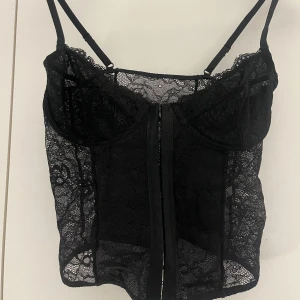 Spetskorsett - Svart spetskorsett ifrån Nakd