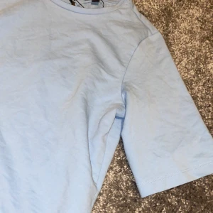 T-shirt  - En super fin baby blå t-shirt med lite längre ärmar. Helt ny! 