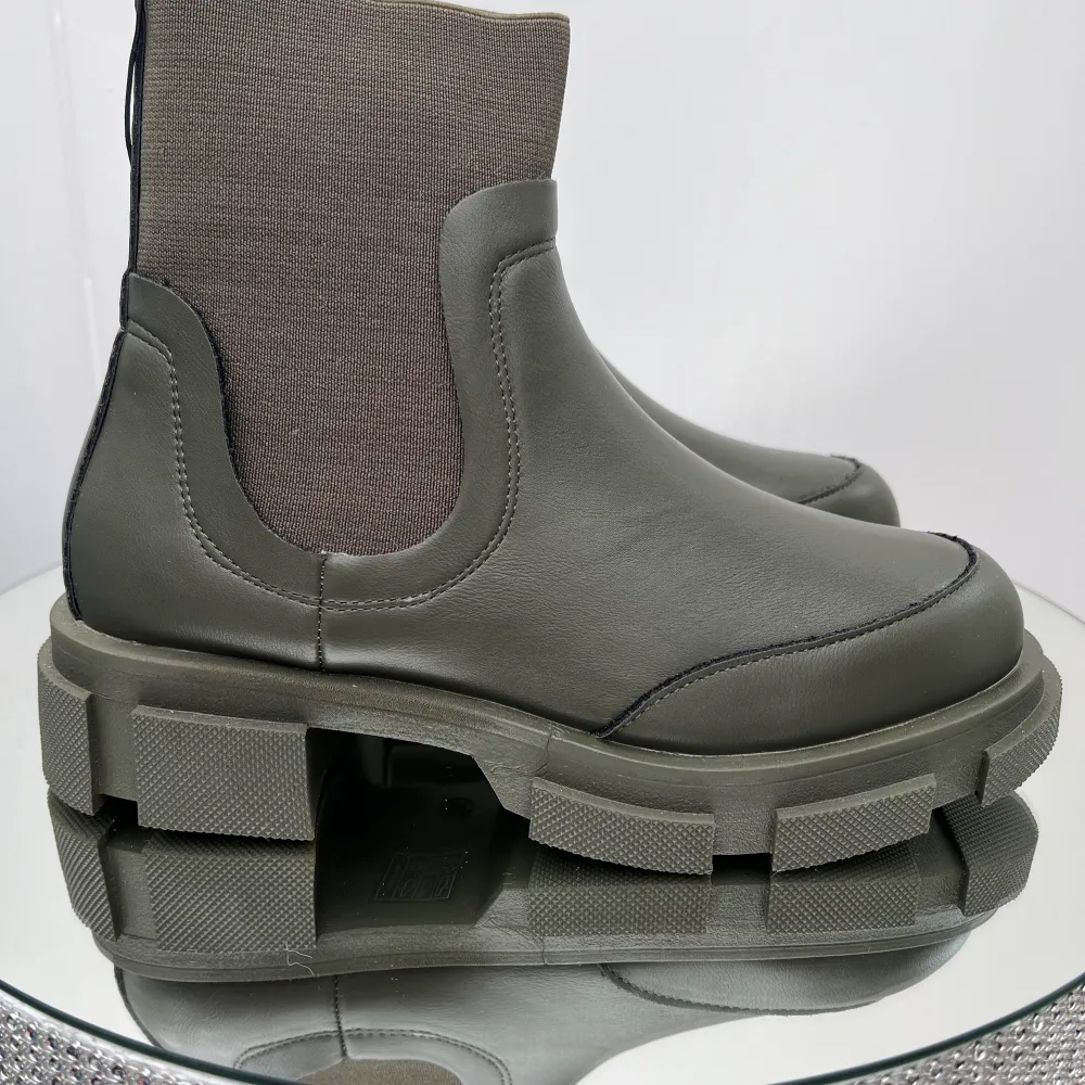 Låga boots med en chunky design. Bootsen är gröna och har grova sulor. De har en resår på sidorna. Ord pris 599kr. Skor.
