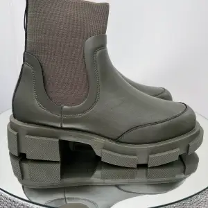Låga boots med en chunky design. Bootsen är gröna och har grova sulor. De har en resår på sidorna. Ord pris 599kr