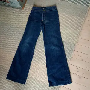 Nu säljer jag ett par 70-tals jeans. De är i nyskick och har knappt använts. Mått: ca 84 cm  innerbensmått, ca 70 cm midja och ca 30 cm heckmått 