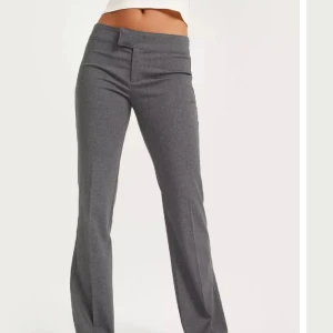 Gråa kostymbyxor från nelly - Säljer dessa superfina lågmidjade kostymbyxor från Nelly. De är jättesköna och i bra skick men för stora för mig tyvärr💗