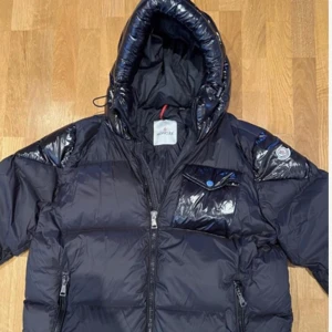 Moncler jacka  - Moncler jacka i storlek 5 (XXL). Har en pytteliten reva (se bild) som är lagad med en  liten lapp, hör av er vid intresse.