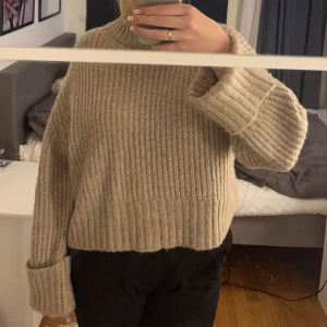 Snygg stickad tröja - Stickad, beige tröja med detaljer på ärmarna 