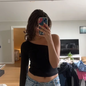 One shoulder top - Säljer denna supersnygga svarta one shoulder tröjan från NAKD. Använd en gång och i storlek S. Det är en body men jätteenkel att vika in. 