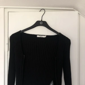 Tight svart kofta - Säljer denna sjukt fina tighta ribbade koftan från NA-KD, säljer då den inte kommer till användning 