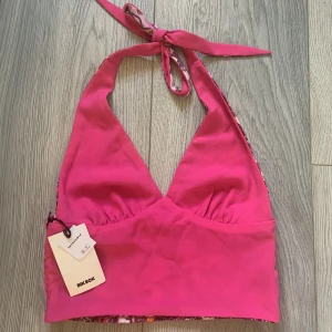 Topp  - Säljer en oanvänd topp med öppenrygg och knytning vid nacken (prislapp kvar). Toppen är i storlek S och går att välja mellan att bära hel rosa eller mönstrad💖